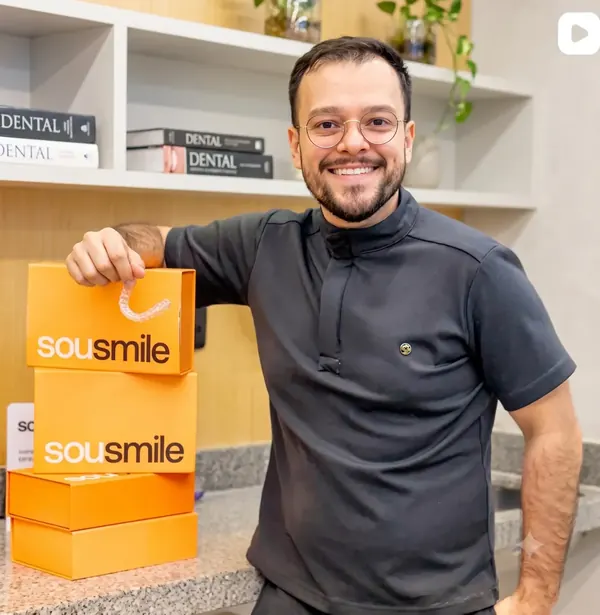 Caixas de alinhador invisível na recepção da clínica, com o alinhador transparente em destaque.
