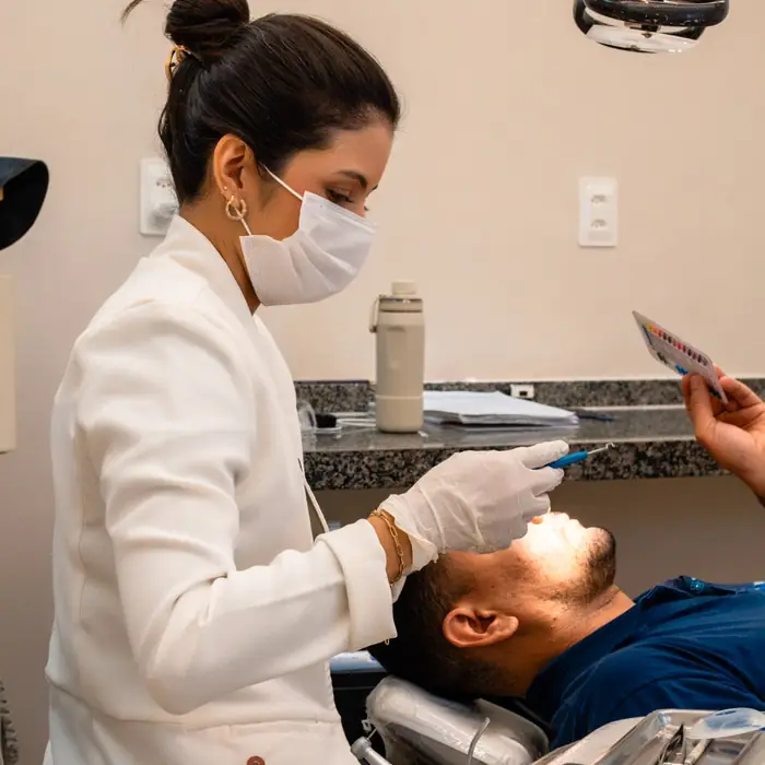 Dentista da equipe DS Odonto em atendimento a uma paciente no consultório
